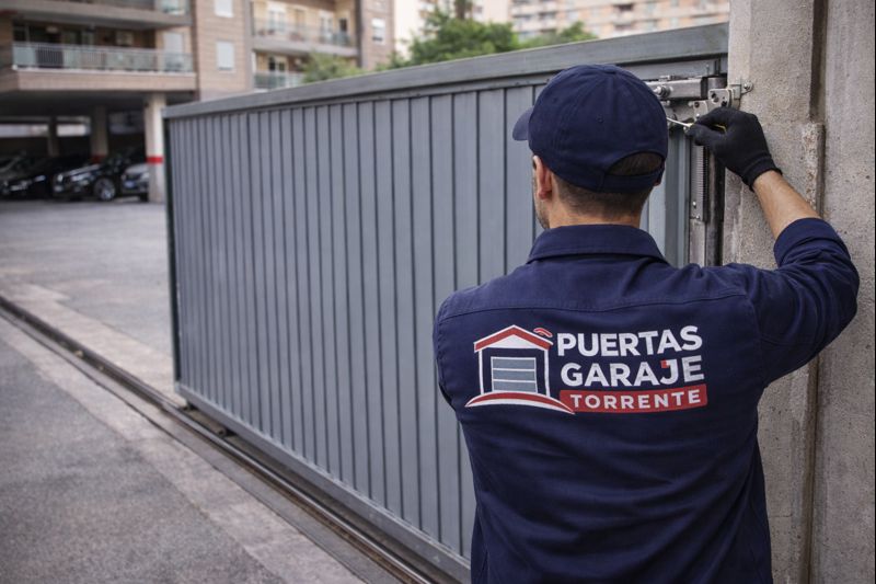 Técnico de Puertas Garaje ajustando una puerta corredera de garaje