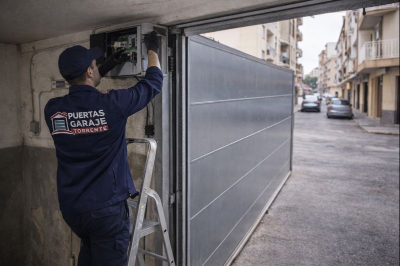 Técnico de Puertas Garaje Torrente revisando el motor interior de una puerta de garaje en Alaquàs